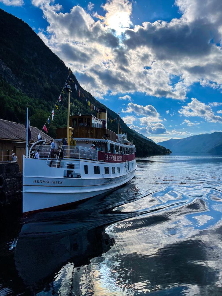 Telemarkskanalen med kanalbåt, klart vann, fjell og fjord i bakgrunn