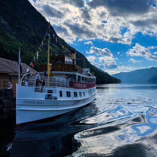 Lårdal Tretopphytter – Telemarkskanalen| Telemarkskanalen med kanalbåt, klart vann, fjell og fjord i bakgrunn